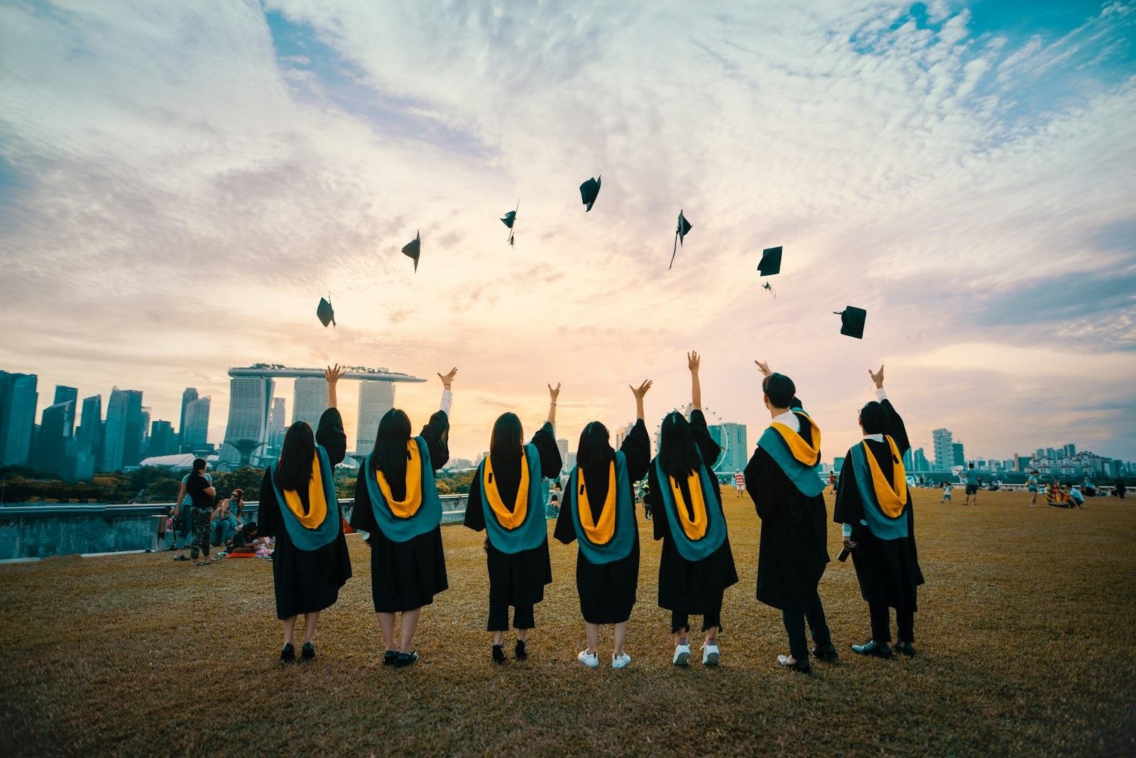 Egresados lanzando sus birretes en la graduación